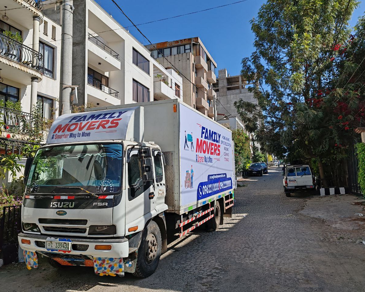 Family Movers Ethio branded moving truck parked on a residential street in Addis Ababa, displaying home moving, office relocation, packing, cleaning, and storage services